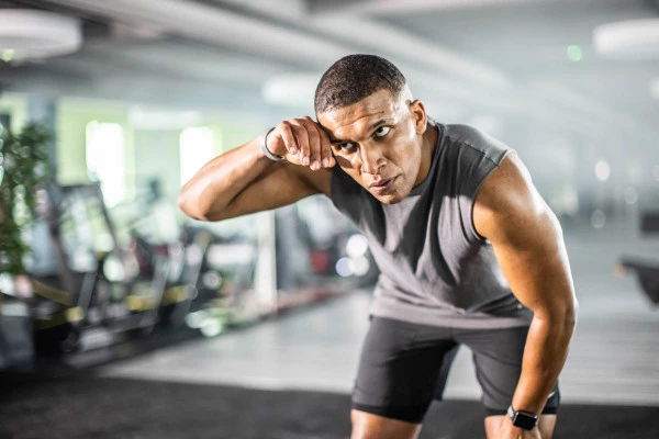 Trainingsziel Kondition verbessern Mann erschöpft im Fitnessstudio