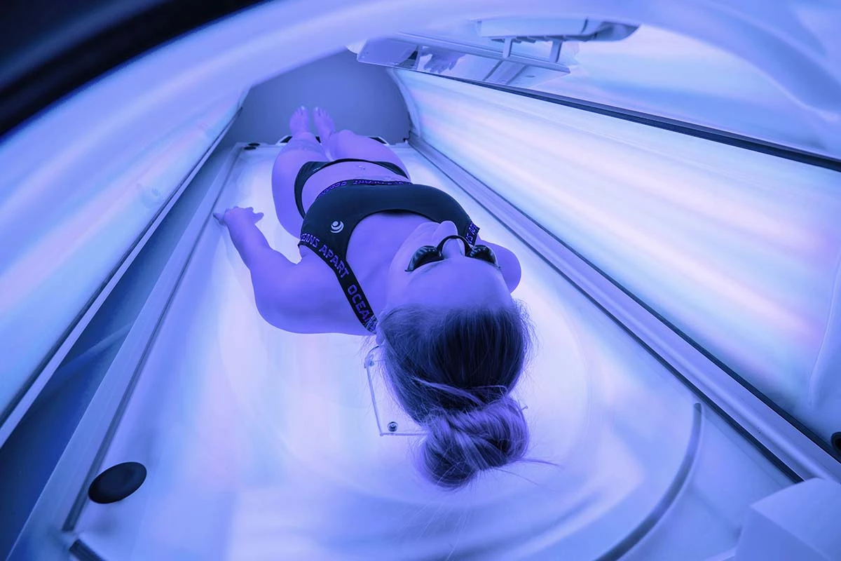 Frau will sich im Solarium bräunen